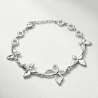 Damenarmband mit mehreren glatten Metallreihen und polierten Kugelenden, in silberner Optik am Handgelenk und als Detailansicht dargestellt