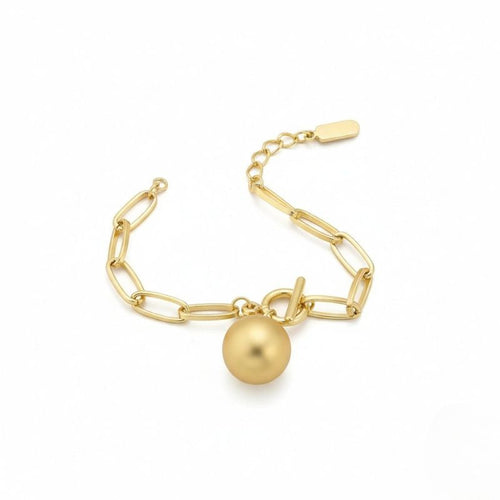 Goldfarbenes Damen-Gliederarmband mit Kugelanhänger, getragen am Handgelenk und in Nahaufnahme dargestellt